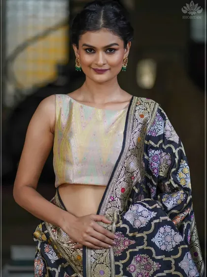 The same beautiful pale gold brocade blouse, shown here with a richly woven Banarasi saree. Its simplicity allows the saree's intricate patterns to take center stage.