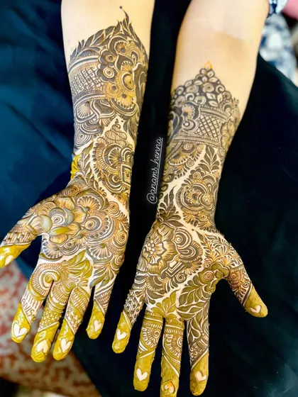A stunning pair of bridal hands with matching intricate designs. The patterns are a mix of Pakistani and Indian styles, with lots of fine detail work.