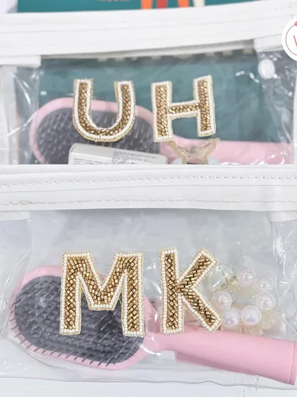 Personalized clear pouches with beaded initials are a chic and practical gift for bridesmaids, perfect for keeping essentials organized during the wedding festivities.