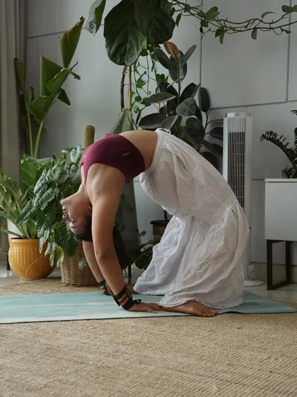 Ustrasana, or Camel Pose, on the mat. This version shows a deep arch, with the hands on the heels, which requires a good amount of spinal flexibility and trust.