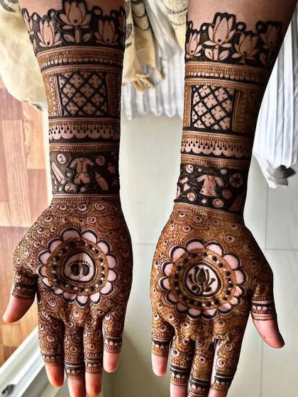 A sweet baby shower design with tiny footprints in a central mandala. The arms feature other baby-related motifs like clothes and rattles, celebrating the upcoming arrival.