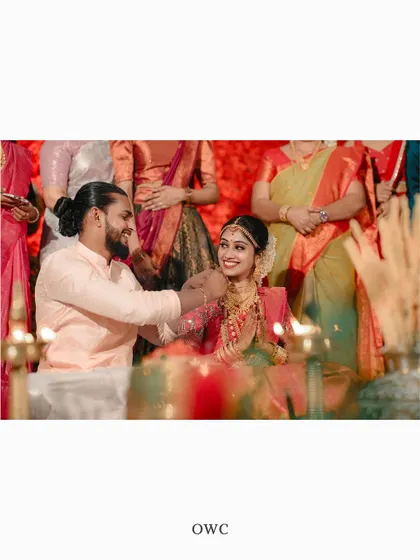 An intimate moment from the wedding ceremony, with the groom lovingly touching the bride's chin.
