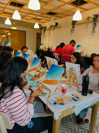 A different angle of the corporate painting session, showing the focus and enjoyment of the participants.