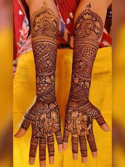 A harmonious blend of portraiture and pattern. The couple's portrait on the palms is surrounded by flowing peacock and paisley motifs that extend up the arms, creating a sense of movement and grace.