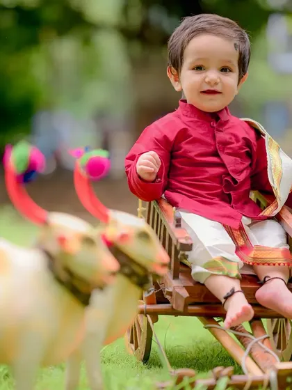 Dressed in a vibrant red silk kurta, little Charul looks like royalty on the mini bullock cart. These traditional outfits add so much richness and meaning to a child's portrait session.