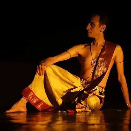 A relaxed, seated pose on stage during "Ṛtu Vismruthi." These moments of quiet reflection are just as important as the dynamic dance sequences.