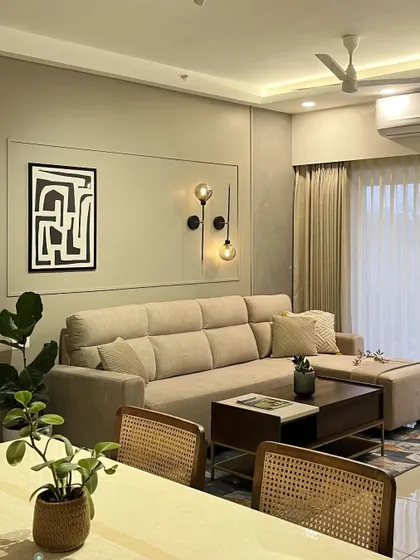 A comfortable living space featuring a beige L-shaped sofa and abstract wall art. The design is simple, functional, and perfect for a modern family home.