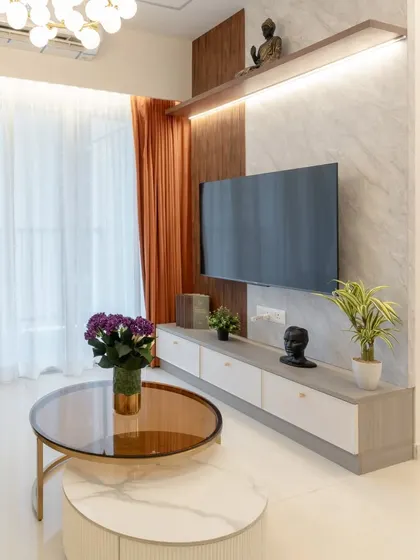 The entertainment wall in this living room combines a marble-finish panel with wooden rafters and integrated lighting, creating a warm and luxurious focal point.