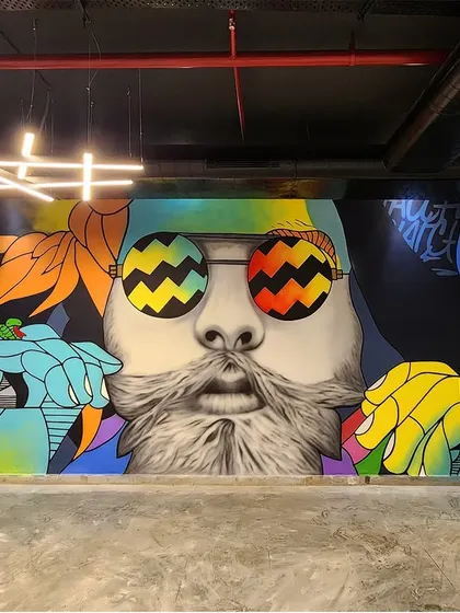 This massive, psychedelic graffiti mural for HR7 Fitness in New Delhi is a true showstopper. The central portrait with vibrant, patterned sunglasses is surrounded by abstract shapes and lettering, creating an explosion of color and energy.
