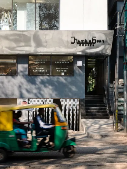 The facade of Humble Bean, a modern architectural statement on a busy Bengaluru street.