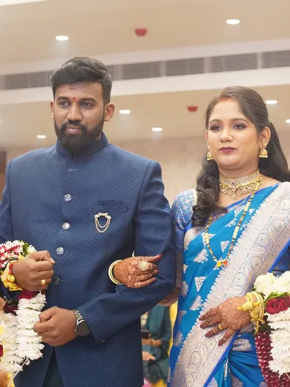The bride and groom walking arm-in-arm. Her makeup is sophisticated and designed to last, ensuring she looks flawless all evening.