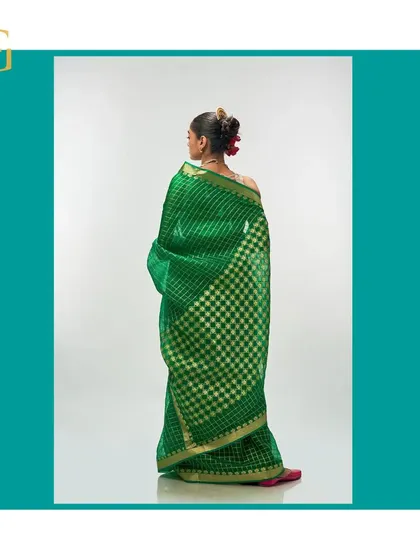 Another angle of the shamrock green saree from the back, emphasizing its vibrant color and luxurious texture.