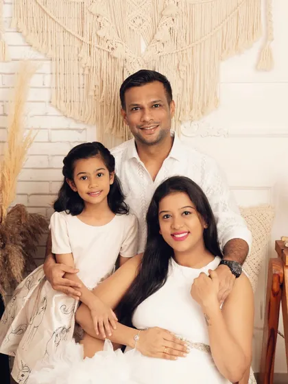 A radiant family portrait during a maternity session. The smiles and loving gazes show a family filled with happiness and excitement for their new chapter.