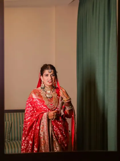 Another lovely shot of the bride checking her reflection, capturing her happiness and the beauty of her traditional look.
