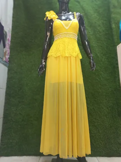 This glamorous yellow gown is perfect for a Haldi ceremony, cocktail party, or pre-wedding shoot. It features a delicate lace and pearl top with a sheer flowing skirt.