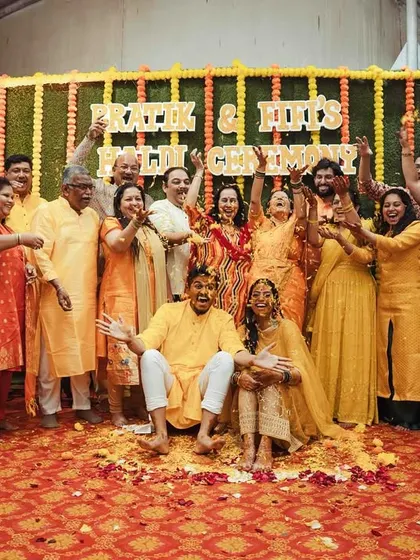 A group photo of the entire family after the Haldi, everyone united in celebration and covered in yellow.