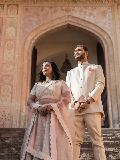 A regal, confident pose on the steps of a historic Jaipur monument. The couple stands side-by-side, their posture exuding grace and strength.