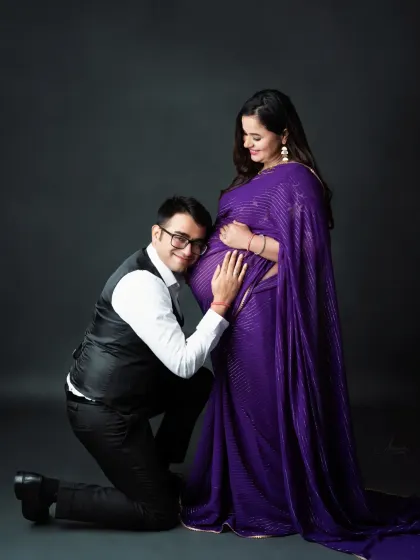 A fun and loving moment. The dad-to-be listens to the baby bump with a huge smile, sharing in the joy of pregnancy.