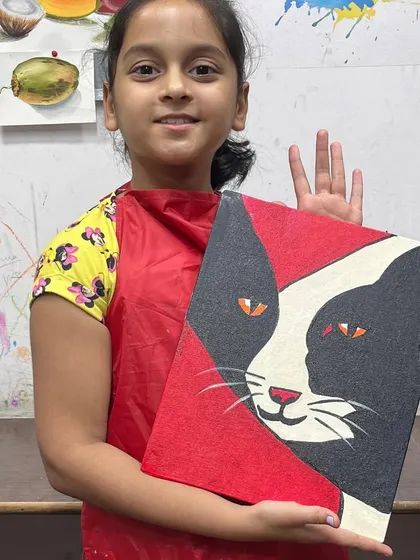 This student is thrilled with her bold, graphic cat painting. We encourage kids to experiment with color and composition to express their own creative vision.