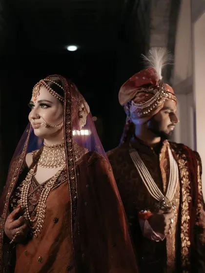 A moody and artistic portrait of the couple in a dimly lit corridor, the window light creating a dramatic and intimate feel.