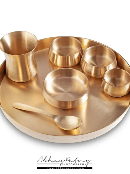 Clean, crisp, and ready for your online store. This e-commerce shot of a brass thali set was photographed against a pure white background to eliminate distractions and focus entirely on the product's form and metallic finish.