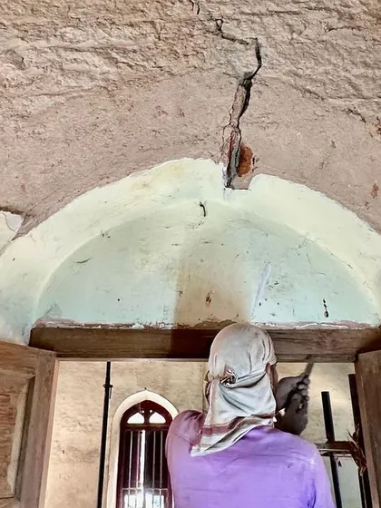 A repeat image of a worker inspecting a ceiling crack, emphasizing the diagnostic phase of our work.