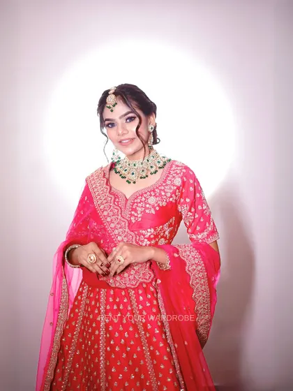 A smiling portrait in the pink lehenga, capturing the joy of dressing up for a special occasion.