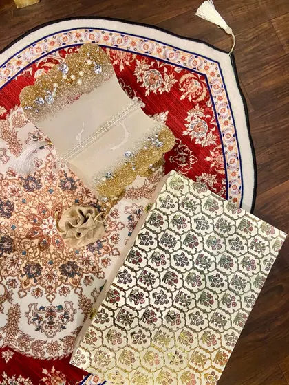 A beautiful Ramadan gift set featuring a dome-shaped prayer mat with an intricate red and white design. The set includes a custom Quran holder and a crystal tasbeeh, making it a perfect gift for the holy month.