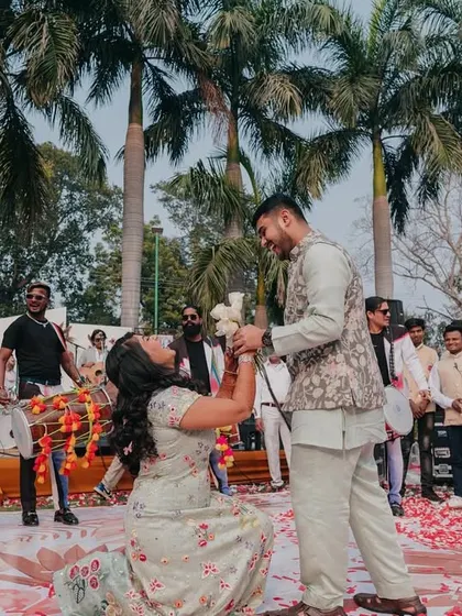 A modern proposal role-reversal! The bride gets down on one knee during a fun-filled event, a moment of joy and empowerment.