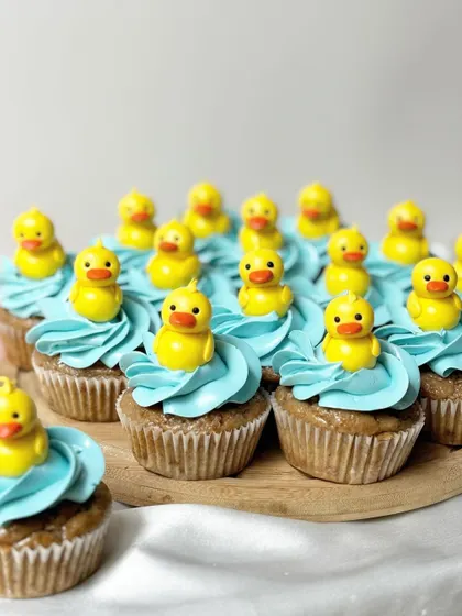 A simple and cute set of rubber ducky cupcakes. Each one features a bright yellow fondant duck sitting on a swirl of blue buttercream that looks like water, making them perfect for a first birthday or baby shower.