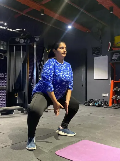 A client demonstrating a perfect bodyweight squat. Mastering fundamental movements like this is the first step towards building a strong and resilient body.