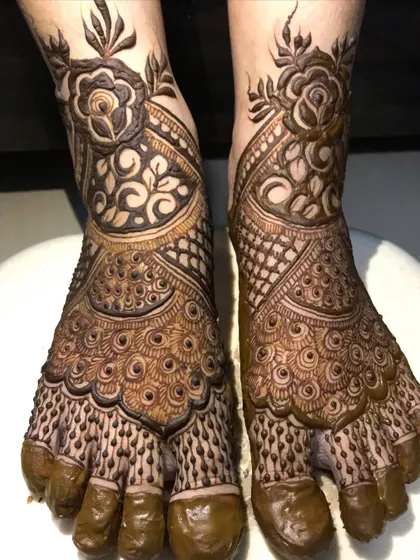 The full view of the peacock-themed bridal foot mehendi.