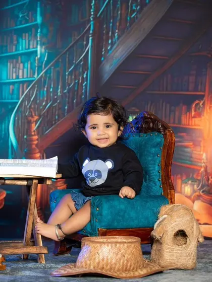 This little one is enjoying his book in the cozy library chair.