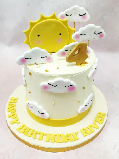 We create a sky full of sunshine with this dreamy and cheerful cake. A smiling sun peeks out from behind fluffy, sleeping clouds on a pristine white cake, making for a serene and happy fourth birthday celebration.