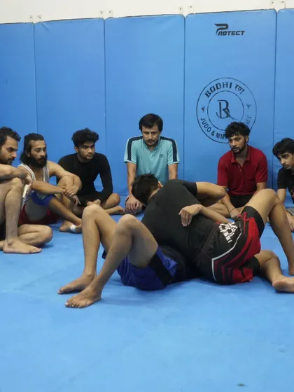 I am demonstrating a ground technique to a group of attentive students. We break down every move step-by-step to ensure everyone understands the mechanics.