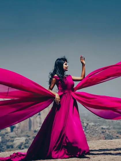 A solo shot of the magenta trail gown, showcasing its incredible length and how it catches the wind for breathtaking photos.
