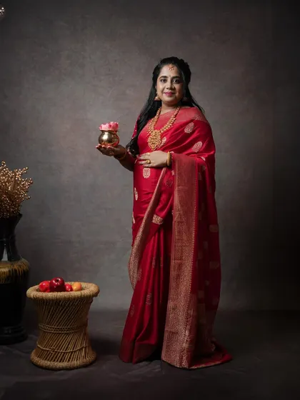 This full-length portrait showcases the elegance of traditional attire for a maternity shoot. The studio setup is kept minimal to let the mother-to-be and her beautiful saree shine.