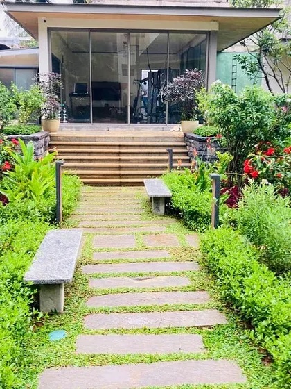 Stone benches are integrated into the garden path, offering a place to rest and enjoy the dense, layered plantings that provide a sense of privacy and enclosure.