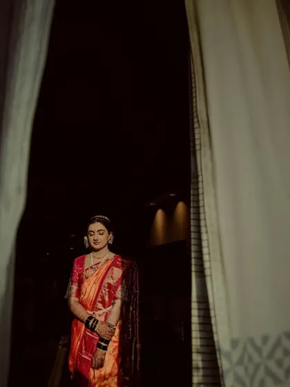 A peeking shot of the bride through a curtain, creating a sense of anticipation.