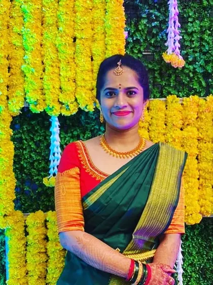 Nikitha in another look for her wedding events, a simple but elegant red blouse paired with a dark green saree.