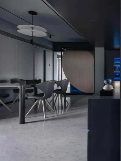 The dining space, showing how the slatted partition and curated furniture create a sophisticated yet functional area.