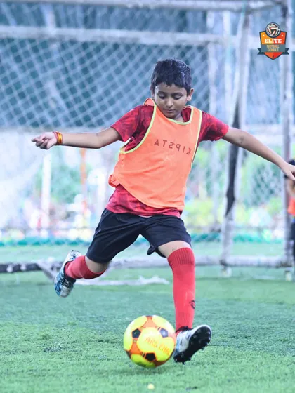 Perfecting the strike. A youth player practices his shooting technique. Repetition and expert feedback are key to developing a powerful and accurate shot.