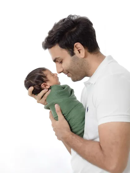 A father's world in his hands. This portrait beautifully captures the awe and love in a new dad's eyes as he holds his baby.