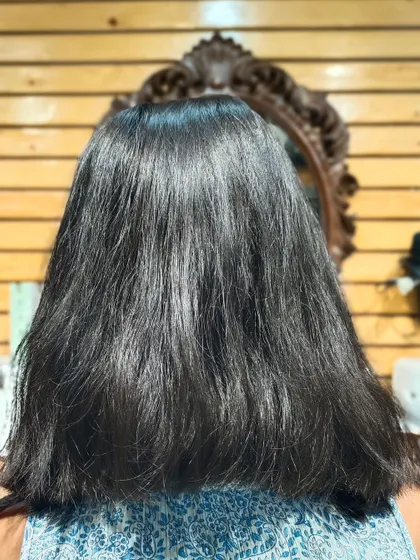 The "before" photo, showing the client's natural dark hair.