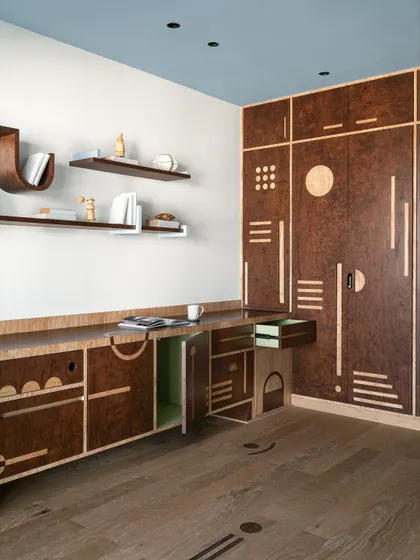 Another angle of the custom burl veneer cabinetry, showing the hidden storage and the beautiful craftsmanship.