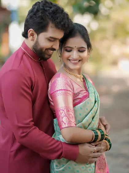 A close-up of the couple's embrace, focusing on their joyful expressions. The bride's mint green and pink saree stands out beautifully.