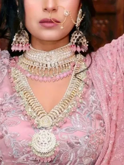 This look shows how we can play with colour. The layered Polki and pearl set is customized with soft pink beads to perfectly match the bride's pastel pink lehenga, creating a cohesive and modern bridal style.