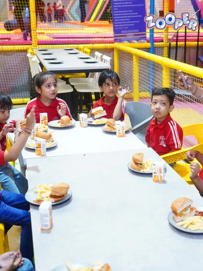 A group of students enjoying their burgers and fries. My meal options are kid-friendly and perfect for refueling after playing.