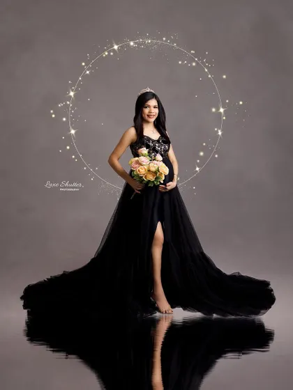 A magical portrait in a black gown, with a sparkling halo of light creating a celestial, dreamy effect.