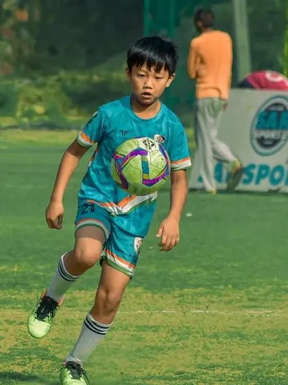 A young player shows great technique controlling the ball on their chest.